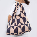 Woman carrying a geometric-patterned bag on a white background